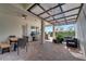 Spacious covered patio boasting brick pavers, two grill areas, comfortable seating, and a ceiling fan at 8498 Powder Ridge Trl, Windermere, FL 34786