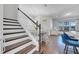 A staircase with a wood handrail and white risers ascends near a dining area and kitchen at 8498 Powder Ridge Trl, Windermere, FL 34786