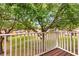 View from a balcony overlooking a large, well-maintained grassy area with mature shade trees at 8534 Crystal Cove Loop, Kissimmee, FL 34747