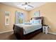 Inviting bedroom with a dark wood bed frame, soft blue bedding, and a ceiling fan for comfort at 8534 Crystal Cove Loop, Kissimmee, FL 34747