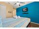 Bright bedroom featuring a TV, mounted on a vivid blue wall, with a ceiling fan at 8534 Crystal Cove Loop, Kissimmee, FL 34747