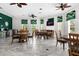 Community room with tables, chairs, a TV above a fireplace, tiled floors, and multiple ceiling fans at 8534 Crystal Cove Loop, Kissimmee, FL 34747