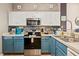 Galley kitchen with white and blue cabinets, stainless steel appliances, and tiled backsplash at 8534 Crystal Cove Loop, Kissimmee, FL 34747