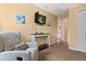 Cozy sitting area features comfortable armchair, mounted TV and beach themed wall art at 8534 Crystal Cove Loop, Kissimmee, FL 34747