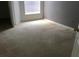 Cozy bedroom with neutral carpet, window, and adjacent doorway at 8817 Dunes Ct # 8-303, Kissimmee, FL 34747