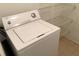 White washing machine with wire shelving in laundry room at 8817 Dunes Ct # 8-303, Kissimmee, FL 34747