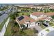 Aerial view of a beautiful home with a tile roof, solar panels, and a spacious driveway with lush green landscaping at 8999 Croquet Ct, Davenport, FL 33896