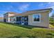 Expansive backyard with verdant grass, showcasing the home's rear facade and a screened-in porch at 8999 Croquet Ct, Davenport, FL 33896