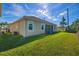 Well-maintained backyard featuring a lush lawn and the home's rear exterior, providing a serene outdoor space at 8999 Croquet Ct, Davenport, FL 33896