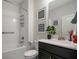 Clean bathroom with a shower-tub combo, modern fixtures, and a black vanity at 8999 Croquet Ct, Davenport, FL 33896