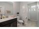 Well-lit bathroom featuring a single sink, neutral color palette, and a toilet with decorative wall art at 8999 Croquet Ct, Davenport, FL 33896