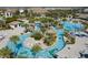 Aerial view of community pool and lazy river with lush landscaping and plenty of room to relax at 8999 Croquet Ct, Davenport, FL 33896