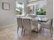 Modern dining room with stylish chandelier and ample natural light from large windows at 8999 Croquet Ct, Davenport, FL 33896