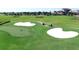 Scenic view of lush green golf course with sand traps, putting green and golf carts at 8999 Croquet Ct, Davenport, FL 33896