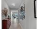Bright, neutrally decorated hallway with tile floors and a gallery wall at 8999 Croquet Ct, Davenport, FL 33896
