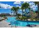 Beautiful lazy river feature with swaying palm trees, lush landscaping, slides and lounge areas at 8999 Croquet Ct, Davenport, FL 33896