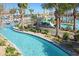 Beautiful lazy river feature with swaying palm trees, lush landscaping, slides and lounge areas at 8999 Croquet Ct, Davenport, FL 33896