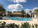 Community pool featuring a tiki hut, clear water, and a meticulously maintained brick deck, perfect for relaxation at 8999 Croquet Ct, Davenport, FL 33896