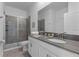 Bathroom featuring a walk-in shower with glass door, double vanity, and granite countertops at 9190 Sommerset Hills Dr, Davenport, FL 33896