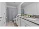 Elegant bathroom features a double vanity, modern fixtures, and a shower with stylish chevron shower curtain at 9190 Sommerset Hills Dr, Davenport, FL 33896