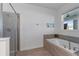 The main bathroom features a large soaking tub, a separate shower, and a window at 9190 Sommerset Hills Dr, Davenport, FL 33896
