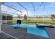 Backyard pool and spa with a basketball hoop, enclosed by a screened lanai at 9190 Sommerset Hills Dr, Davenport, FL 33896