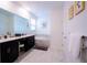 Bright bathroom features double vanity, soaking tub with marble surround, and decorative wall art at 1025 Leader St, Davenport, FL 33896