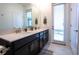 Bathroom showcasing double sinks, dark wood cabinets, and direct outdoor access at 1025 Leader St, Davenport, FL 33896