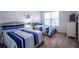 Bedroom featuring two beds with striped bedding, whimsical wall decor and a bright window at 1025 Leader St, Davenport, FL 33896