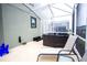 Outdoor hot tub in screened lanai with lounge chair and blue chairs at 1025 Leader St, Davenport, FL 33896