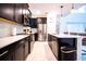 Modern kitchen with stainless steel appliances, black cabinets, white subway tile backsplash, and an island with pendant lighting at 1025 Leader St, Davenport, FL 33896
