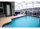 The screened pool area features a sparkling pool, patio area, and comfortable lounge chairs at 1025 Leader St, Davenport, FL 33896