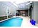 The screened pool area features a sparkling pool, patio area, a grill and comfortable lounge chairs at 1025 Leader St, Davenport, FL 33896