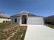 Inviting single-story home featuring a two-car garage and landscaped front yard at 1149 E Grove Ave, Lake Wales, FL 33853