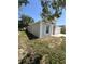 Side view of home features white columns and trim and a well-maintained lawn at 1149 E Grove Ave, Lake Wales, FL 33853