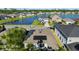 A beautiful aerial view of a neighborhood, a home with solar panels, and a serene lake at 1153 Augustus Dr, Davenport, FL 33896