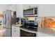 Modern kitchen with granite countertops, stainless steel appliances, and white cabinets at 1153 Augustus Dr, Davenport, FL 33896