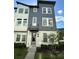 Modern three-story townhome featuring a two-tone exterior and well-manicured landscaping at 12673 Yoshino Aly, Orlando, FL 32827