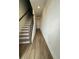 Bright hallway with hardwood flooring and staircase with modern dark wood railing at 12673 Yoshino Aly, Orlando, FL 32827