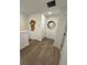 Upstairs hallway with laminate flooring and decorations on the white walls at 12673 Yoshino Aly, Orlando, FL 32827
