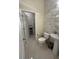 Stylish half bathroom with textured accent wall, sleek fixtures, and pedestal sink at 14129 Walcott Ave, Orlando, FL 32827
