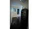 Hallway with dark hardwood floors and decorative artwork and shelving at 14129 Walcott Ave, Orlando, FL 32827