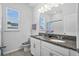 Bathroom with a double sink vanity featuring granite countertops, complemented by bright lighting and a large mirror at 14419 Topaghan Way, Winter Garden, FL 34787