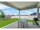 Covered patio with dining set overlooking a spacious backyard and neighborhood view, perfect for outdoor entertaining at 14419 Topaghan Way, Winter Garden, FL 34787