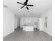 Open-concept living area with gray tile floors, ceiling fan, and modern kitchen at 1449 Monte Carlo Trl, Orlando, FL 32805