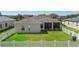 Backyard with a green lawn, white fence, and screened lanai, providing a private outdoor space at 213 Strathmore Cir, Kissimmee, FL 34744
