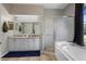 Elegant bathroom with double vanity, glass shower, and a luxurious soaking tub at 213 Strathmore Cir, Kissimmee, FL 34744