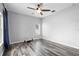 Bedroom features a window for natural light, ceiling fan, and wood-look flooring at 213 Strathmore Cir, Kissimmee, FL 34744