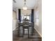 Dining area with dark wood-look floors, a modern table with chairs and natural light at 213 Strathmore Cir, Kissimmee, FL 34744