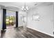 Open dining room has sliding glass doors leading to lanai with modern chandelier at 213 Strathmore Cir, Kissimmee, FL 34744